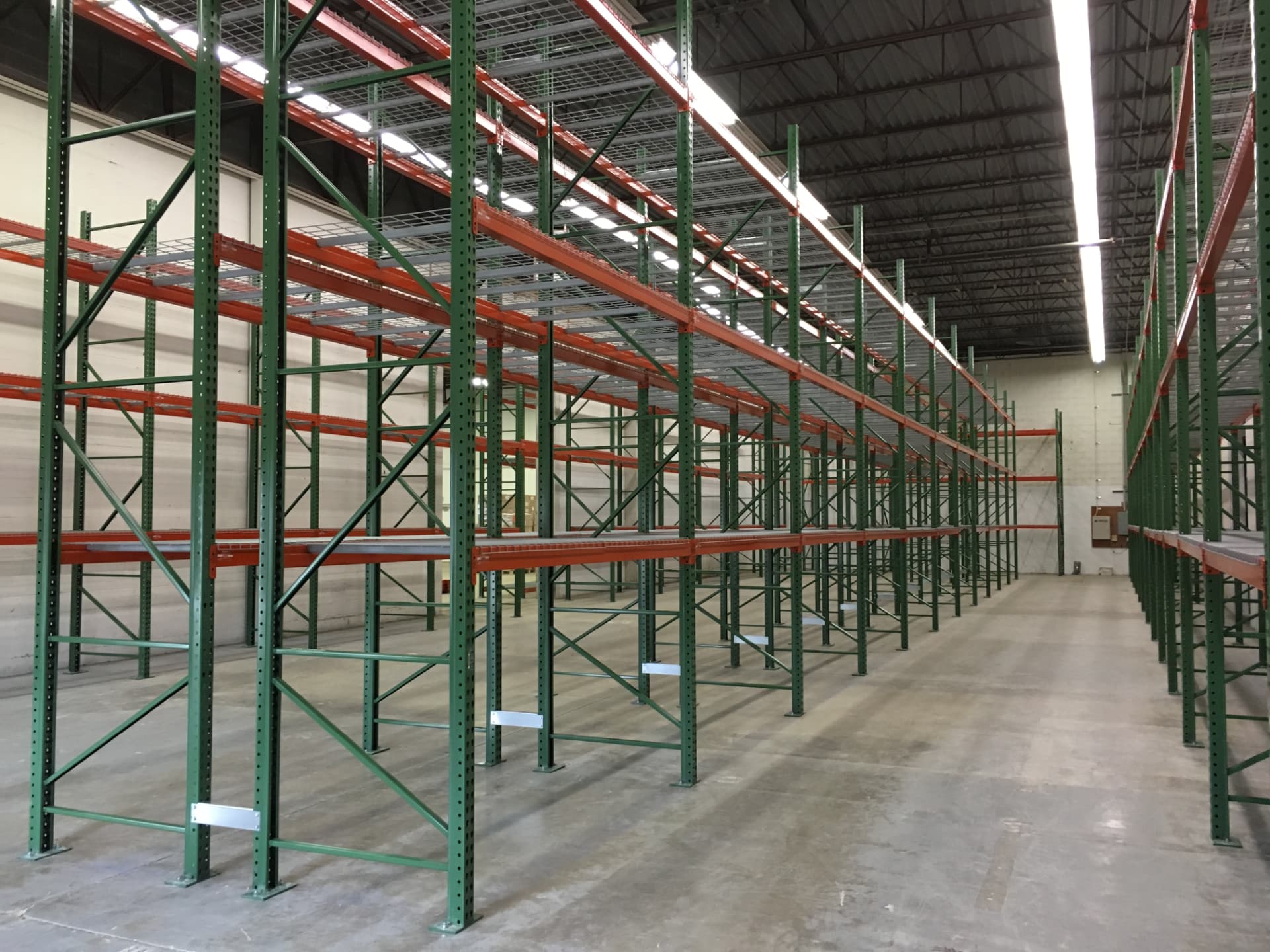 Selective pallet rack installation with green frames and orange beams